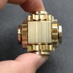 Hand holding gold mechanical cube