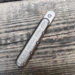 Deep-fried dough sticks metal tool on wooden surface.